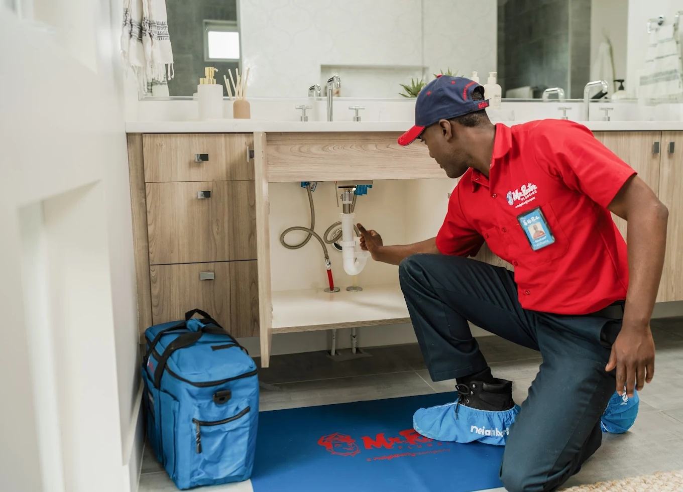 Mr. Rooter technician repairing a bathroom sink drain line in a Katy, TX home